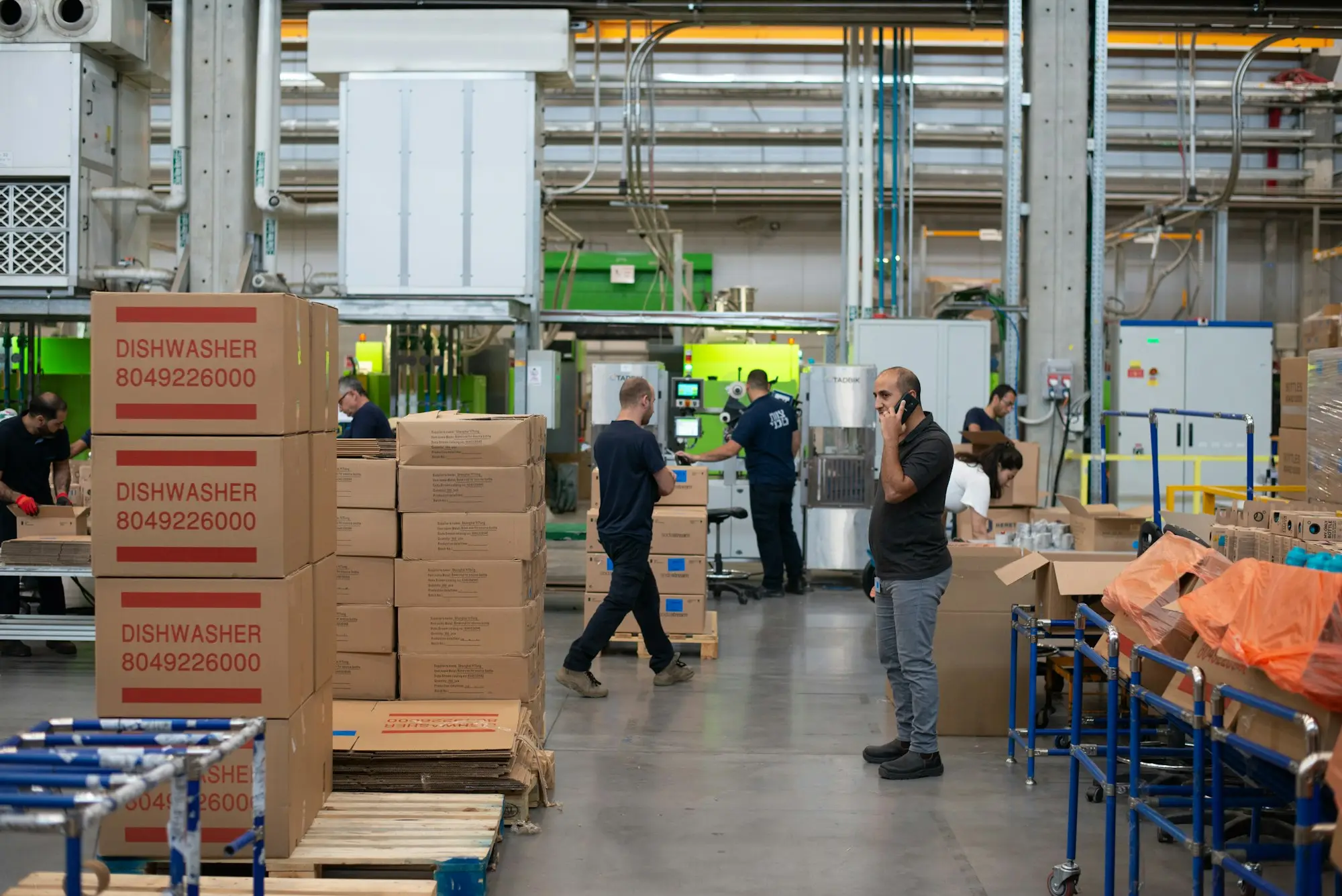 Warehouse with stacked cartons and staff on the floor